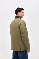 Campera de gabardina color marrón con cuello de pana en tono oscuro. Presenta cierre frontal con botones a presión, bolsillos laterales con solapa y diseño de calce clásico.