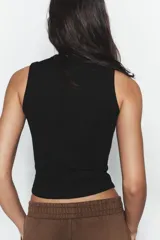 Top musculosa de punto acanalado color blanco, con cuello redondo.