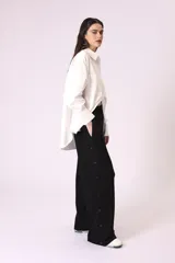 Pantalón de vestir color beige, de corte palazzo y tiro alto, con cierre lateral con botón y cremallera.