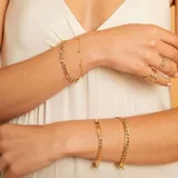 Pulsera de eslabones tipo barbada en oro 9k, con placa central lisa apta para grabado.