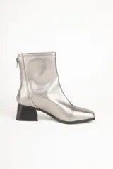 Botas plateadas de caña baja con cierre en la parte trasera, punta cuadrada y taco cuadrado de 5,5cm de alto.