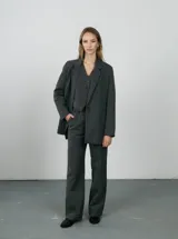 Blazer negro de lana con rayas verticales finas, corte clásico, solapas de muesca y cierre con botones.