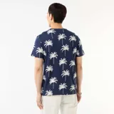 Remera azul marino de manga corta con estampado integral de palmeras blancas.