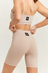 Top deportivo color beige, con breteles regulables, espalda recta y logo ZN.