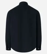 Camisa de manga larga confeccionada en sarga de algodón color verde menta, con cuello inglés y cierre frontal de botones negros. Presenta dos bolsillos de parche con solapa en el pecho y puños con botones.