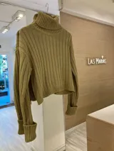 Sweater de punto color verde oliva, con cuello alto y mangas largas con puños acanalados.