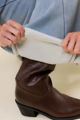 Jean de tiro alto con calce wide leg, confeccionado en denim de lavado celeste claro. Presenta una estructura firme y un interior forrado para mayor abrigo, con bolsillos funcionales.