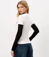 Remera blanca de algodón con cuello redondo y manga corta, con estampa frontal localizada inspirada en el estilo napoleónico en color negro.