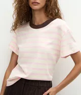 Blusa de corte boxy confeccionada en algodón, con diseño de rayas horizontales, cuello redondo de punto en color contrastante y mangas cortas.