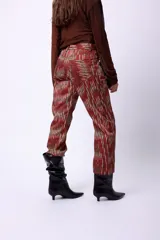 Pantalón recto con estampado abstracto en tonos marrones y negros, tiro medio.