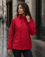 Campera cortaviento impermeable de United Uy, confeccionada en poliéster ultra liviano. Presenta un diseño con estampado botánico en tonos oscuros, capucha ajustable, cierre frontal con solapa y bolsillos laterales.