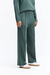 Pantalón de punto de tiro medio con corte recto y fit relajado. Presenta costuras verticales frontales que estilizan la silueta y bolsillos laterales.