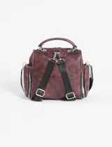 Mochila bandolera de cuero sintético color marrón, con múltiples compartimentos frontales y laterales con cierre metálico. Cuenta con asa superior y correas ajustables para usar como mochila o bandolera.