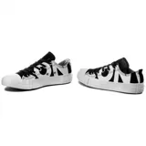Championes Converse Chuck Taylor All Star OX de lona blanca con estampado de letras negras, cordones negros y suela blanca.