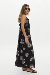 Vestido largo negro con estampa artesanal en tonos claros, escote halter y volados.