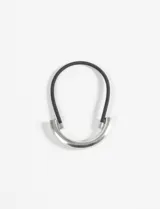 Gomita para el pelo negra con un aplique metálico plateado en forma de U invertida.