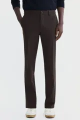 Pantalón sastrero de corte slim fit en color marrón, con pliegues frontales, cierre de botón y trabillas para cinturón.