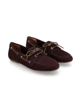 Mocasín tipo náutico de cuero nobuck color bordó, con cordones frontales, ojales metálicos dorados y costuras reforzadas en la puntera.