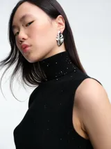 Top sin mangas al cuerpo confeccionado en tejido de viscosa con micro lentejuelas brillantes. Presenta cuello alto y diseño elástico, ideal para diversas ocasiones.