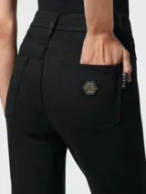 Pantalones acampanados de mezclilla negra Philipp Plein con cierre de botón dorado.
