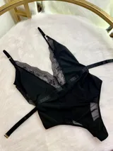Body entallado confeccionado en lycra, microtul y encaje. Presenta breteles regulables, escote en V con detalle de encaje y paneles de microtul en la cintura. Diseño con cierre de gancho en la cintura.