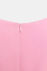 Mono corto rosa chicle, sin mangas, con cuello redondo y detalle de cruce o abertura frontal en la parte inferior. Presenta cierre oculto en la espalda.