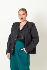 Chaqueta negra de crepe con solapas y borde frontal con lentejuelas. Corte recto y mangas largas.