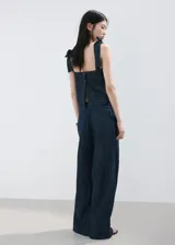 Pantalón de mezclilla azul oscuro, con silueta wide leg, tiro alto y pretina con cordón ajustable.