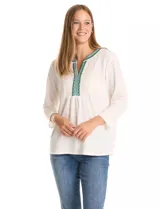 Blusa de tejido crepé color blanco, con mangas tres cuartos y silueta evasé. Presenta un panel frontal con encaje calado y bordados geométricos en tonos verdes y azules alrededor del escote en V.