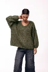 Sweater de punto con textura liviana, escote en V amplio y mangas largas levemente abullonadas. Presenta un calce relajado y holgado.