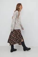 Falda midi de corte irregular con diseño a cuadros en tonos marrones, negros y beige. Presenta una silueta acampanada con caída fluida.