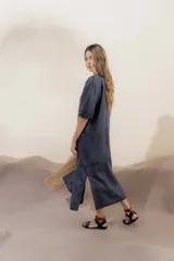 Vestido largo azul oscuro de lino 100% con escote en V, mangas abullonadas con elástico en el puño y pespunte en contraste. Presenta detalle de punto smock en el canesú y bolsillos laterales.