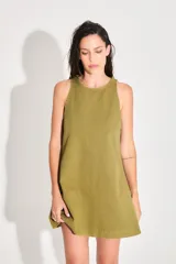 Vestido corto de gabardina color verde oliva, con escote cerrado y silueta amplia.