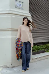 Sweater de punto con textura suave, color beige, de corte holgado y mangas largas con terminación de cuello y puños en estilo rulé.