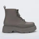 Botas tipo borceguí de la marca Melissa, confeccionadas en material sintético con acabado mate. Presentan diseño de caña media con cordones al tono, suela track de plataforma robusta y tirador en la parte trasera.