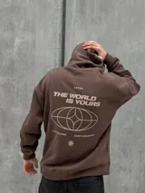 Canguro marrón con capucha ajustable con cordones, bolsillo tipo canguro y puños elásticos. Presenta un logo de un globo terráqueo y una flor bordados en el pecho.