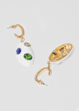 Par de aros colgantes con base de metal dorada, aro superior tipo argolla y dije ovalado de loza blanca con incrustaciones de piedras de colores: verde, azul y marrón.