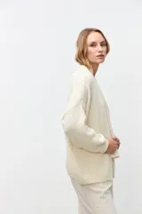 Cardigan abierto de punto color crudo, con mangas largas y corte holgado.