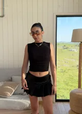 Top sin mangas de tul negro, con diseño reversible que permite variar la transparencia entre el frente y la espalda. Presenta un corte ajustado al cuerpo y cuello redondo.