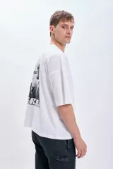 Remera blanca de corte amplio con estampado en la espalda de Mando y Grogu de la serie The Mandalorian, con texto "His name is Grogu".
