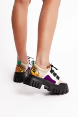 Sneakers de cuero vacuno color beige con detalles en blanco, negro, marrón y violeta. Presenta un cuello acolchado con estampado animal print, cordones negros y suela track negra.