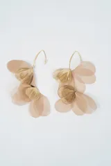 Caravanas colgantes con diseño de pétalos de tela en tono beige y detalles de hojas metálicas doradas con textura estriada.