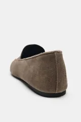 Mocasín plano de serraje color marrón, con diseño de copete subido, pespuntes decorativos en el cuerpo y punta ligeramente perfilada.