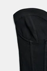 Top tipo corsé negro de Zara Woman Collection, confeccionado en hilatura con mezcla de algodón, con escote corazón y aros. Presenta bajo asimétrico y cierre en la espalda con ganchos metálicos.
