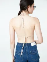 Top tejido al crochet color crudo, con tirantes finos.