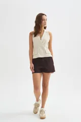 Chaleco sastrero beige de viscosa, con solapas, doble botonadura frontal y bolsillos con solapa en los laterales.