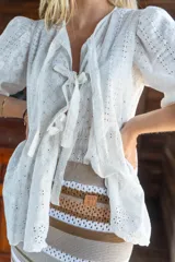 Camisa amarilla de broderie con escote en V, mangas globo y lazos ajustables en el frente.