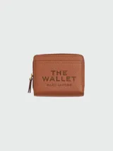 Billetera compacta Marc Jacobs de cuero negro con cierre perimetral y broches dorados. El interior cuenta con múltiples ranuras para tarjetas y compartimento para billetes.