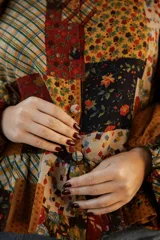 Kimono de lino con diseño patchwork en tonos rojizos y oscuros, con cuello camisero, cierre frontal de botones, mangas largas abullonadas y ruedo con volados.