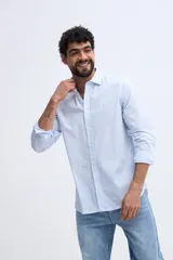 Camisa de manga larga fit semi slim color celeste, con cierre frontal de botones y cuello camisero clásico.